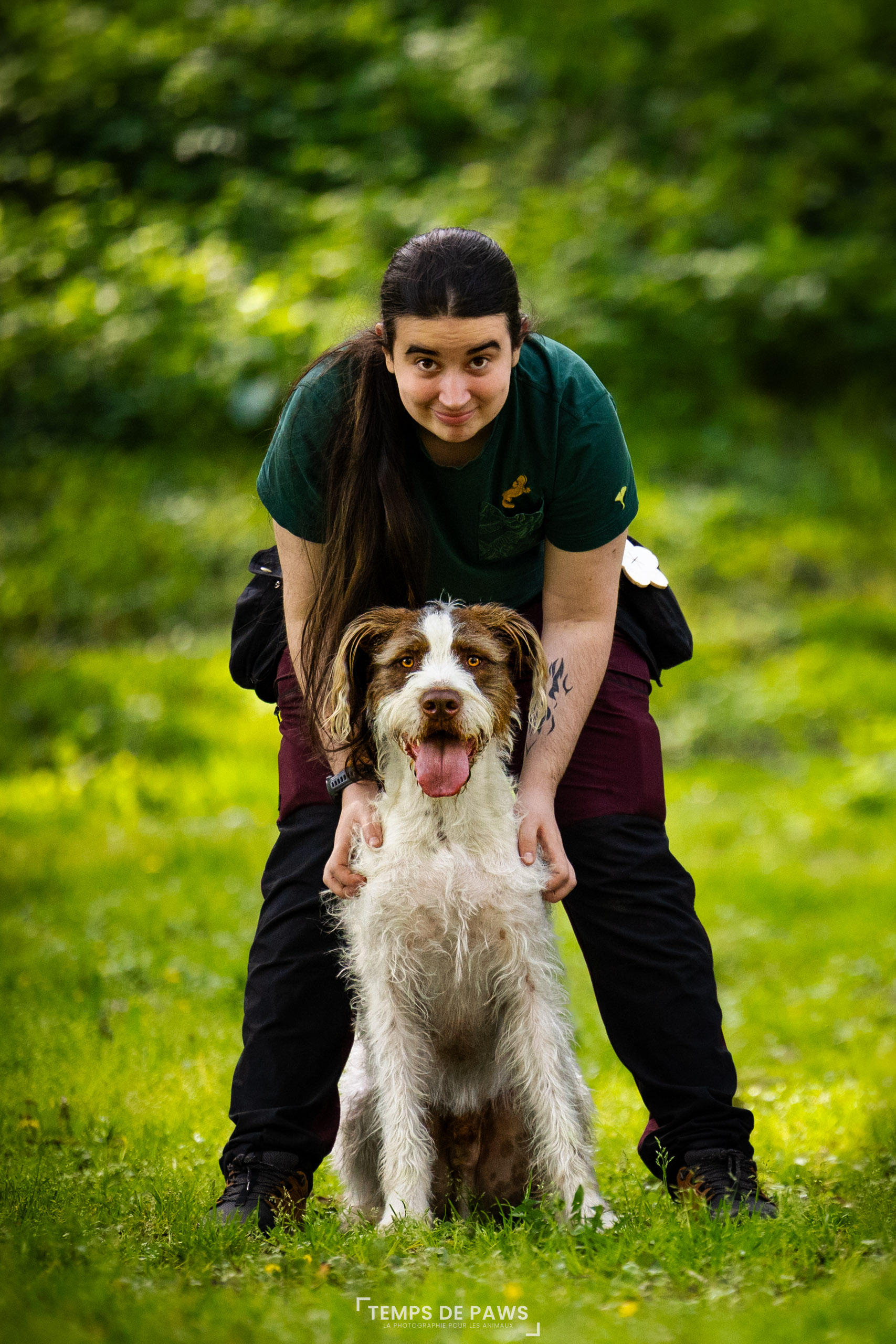 Photo d'un chien qui souris avec un humain à côté