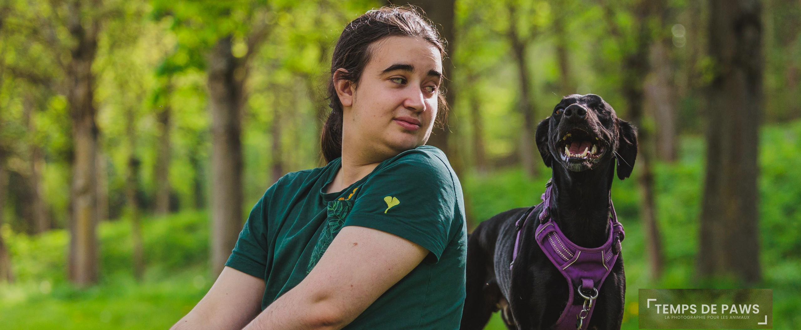 Photo d'un chien qui souris avec un humain à côté